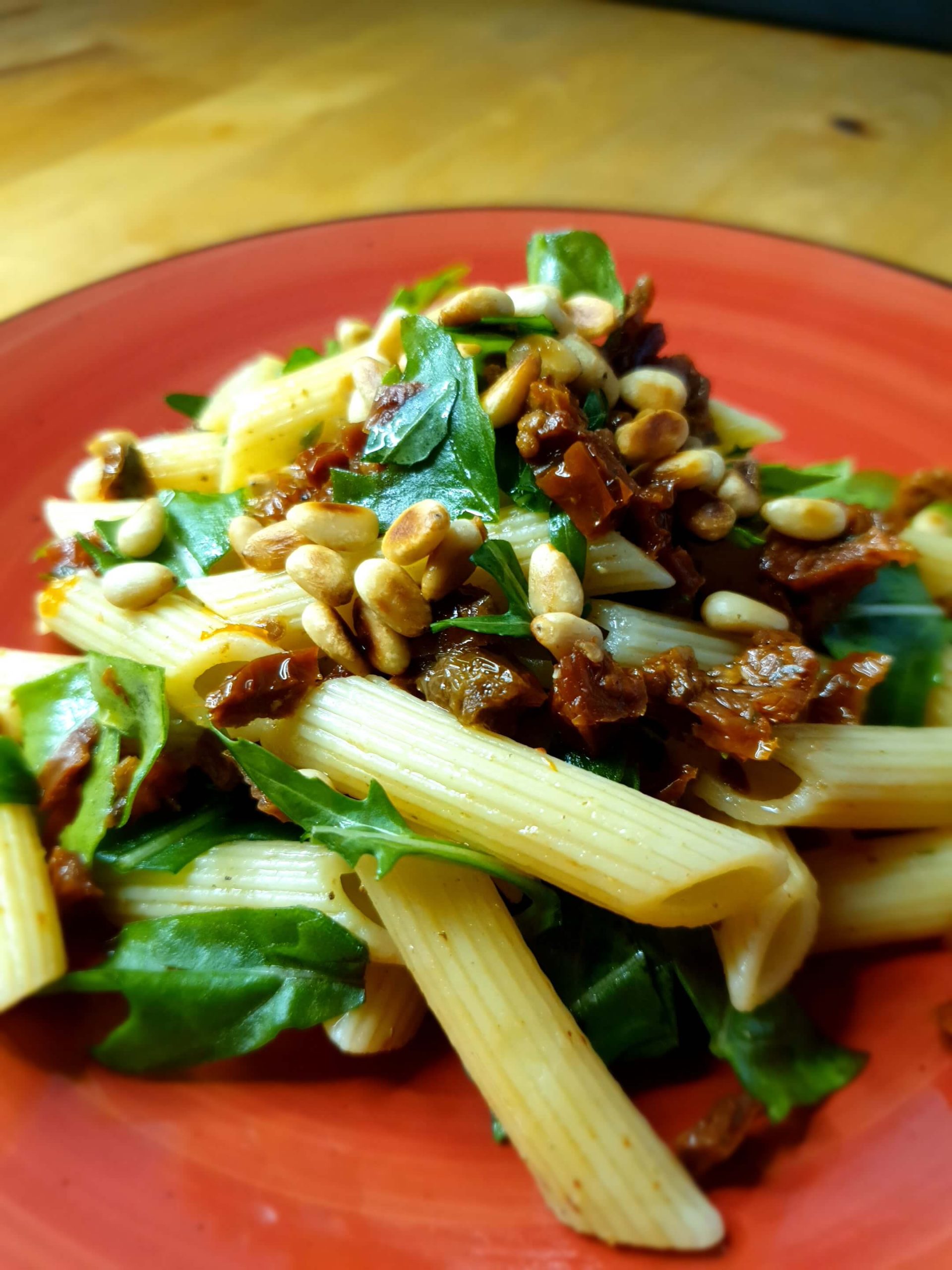 Mediterraner Nudelsalat – schnell gemacht mit nur vier Zutaten: Penne, getrockneten Tomaten in Öl, Rucola und gerösteten Pinienkernen