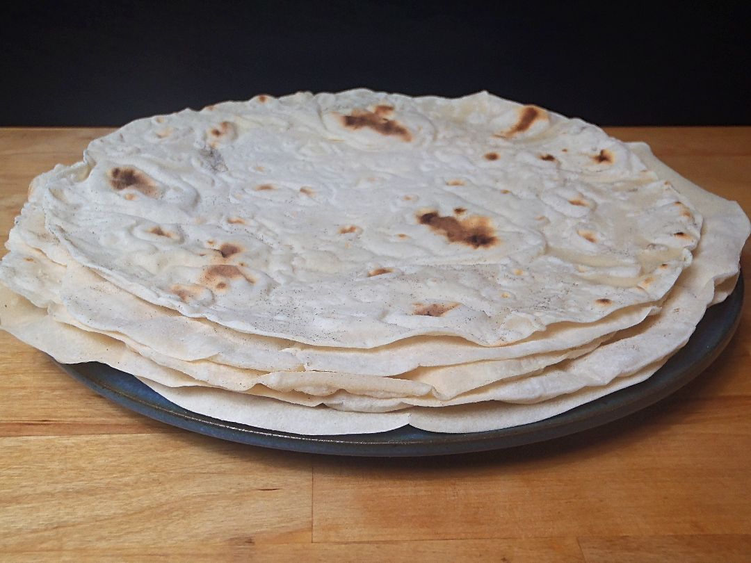 Lavash Fladen Beitragsbild Ein Teller mit zehn dünnen gebackenen Lavash Teigfladen