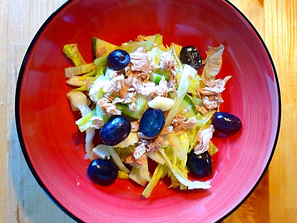Salat mit Thunfisch und Weitrauben_Beitragsbild Ein Teller mit Thunfischsalat, bestehend aus Thunfisch, Eisbergsalat, Mozzarella, Gurke und Weintrauben
