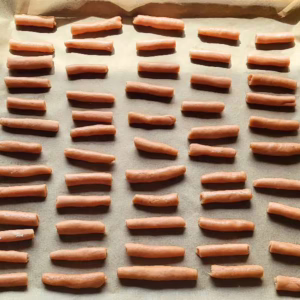 Ein Backblech voll mit gerollten ungebackenen Stangen